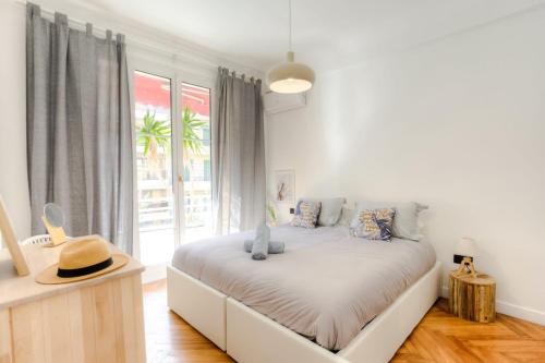 une chambre avec un lit avec un chapeau dessus dans l'établissement #29 Suite Gambetta AC Sea view 2 bedrooms 1min Walk to Promenade & Sea, à Nice