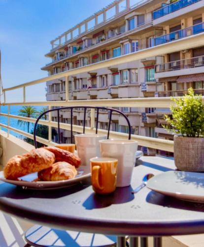 une table avec une assiette de nourriture sur un balcon dans l'établissement #29 Suite Gambetta AC Sea view 2 bedrooms 1min Walk to Promenade & Sea, à Nice
