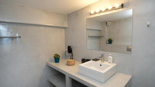 a white bathroom with a sink and a mirror at Eva Villas East, with infinity pool & and panoramic sea view in Gerani