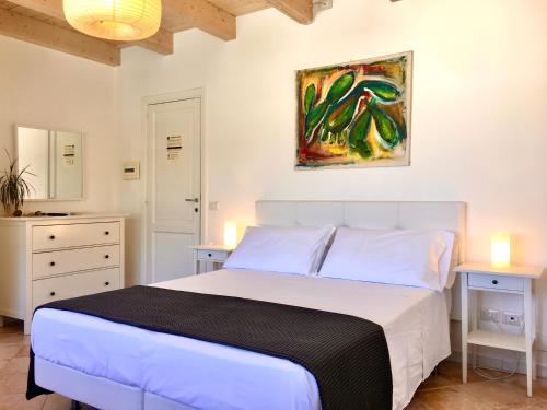 a bedroom with a white bed and a painting on the wall at Casa Mafalda B&B in Lipari