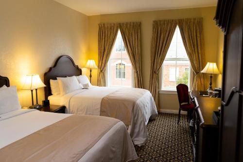 The Mount Vernon Grand Hotel في Mount Vernon: غرفة فندقية بسريرين ونافذة