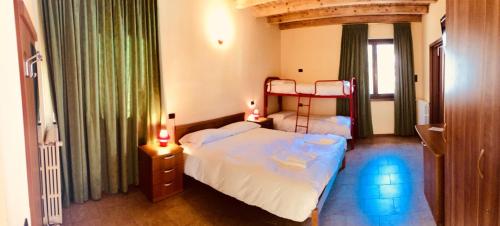 a bedroom with two beds and a large window at Ostello Brembo in Camerata Cornello
