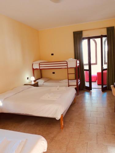 a hotel room with two beds and a balcony at Ostello Brembo in Camerata Cornello