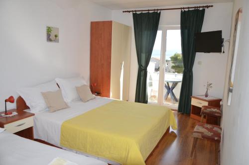 a hotel room with two beds and a balcony at Apartman Mare in Drvenik