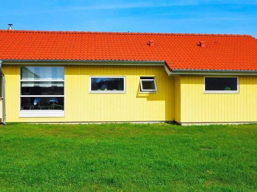 a yellow house with an orange roof at 8 person holiday home in Gro enbrode in Großenbrode
