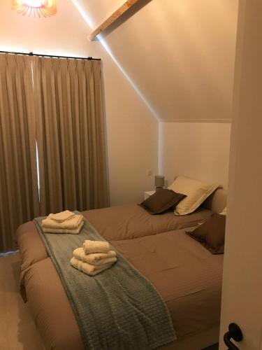 a bedroom with two beds with towels on them at Oscaar vakantiewoning in bos in Koekelare
