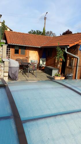 a swimming pool in front of a house at Apartmán u potoka in Sadov