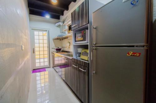 una cocina con refrigerador de acero inoxidable en Yilan Night Market Whole House, en Yilan City