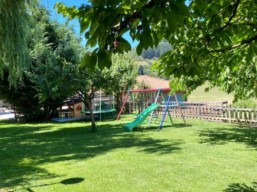 a playground with a slide in a yard at Apartamentos Alquitara in Potes