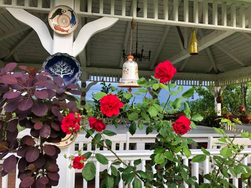 a porch with red flowers and a statue of a rabbit at Conacul Paloși in Horezu