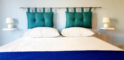 a bedroom with a bed with blue and green pillows at Casa Maris in Alcamo