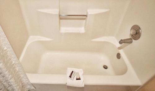 a bathroom with a bath tub with a towel at Claridge Inn - St. George in St. George