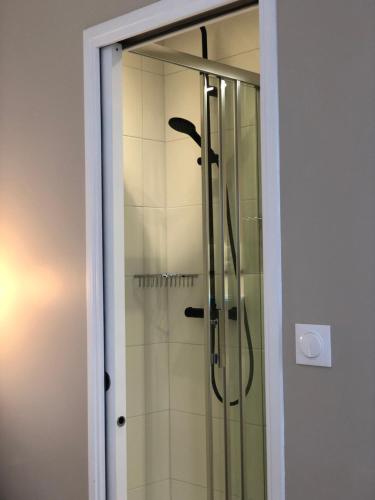 a shower with a glass door in a bathroom at Hôtel Moderna in Cherbourg en Cotentin