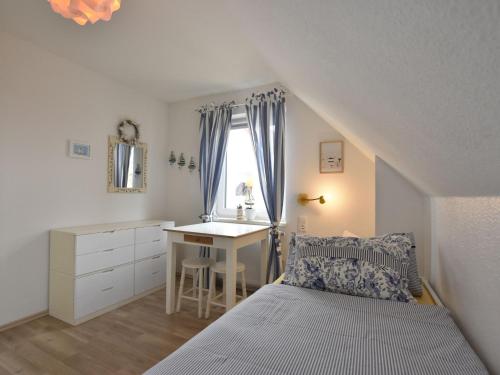 a bedroom with a bed and a desk and a window at Baltic Hus Zierow s Gem in Zierow