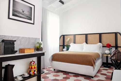 a bedroom with a bed and a table with a tv at Magnolia Boutique Rooms in Catania