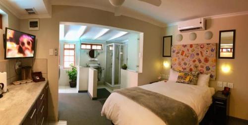 una camera da letto con un letto grande e una cucina di The Travel Inn Durban a Durban