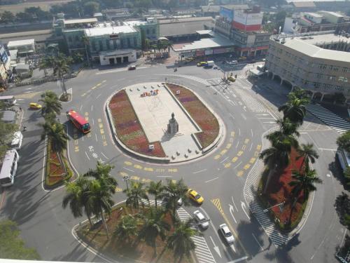 an intersection in a city with cars and a statue at 嵐茵鐵道旅館 in Tainan