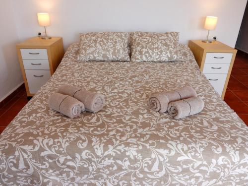 a bedroom with a bed with two pillows on it at Casa Arts guest rooms in Alcaucín