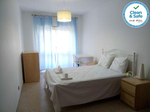 a bedroom with a white bed with two stuffed animals on it at Sol e Praia - Peniche II in Peniche