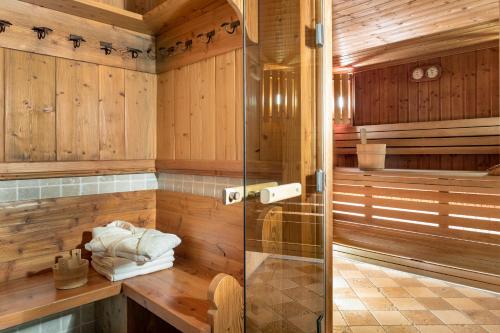 a sauna with wooden walls and a glass shower stall at Logis La Croix-Saint-Maurice in Le Grand-Bornand