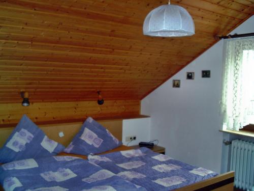 - une chambre avec un lit et un plafond en bois dans l'établissement Ferienwohnung Schmotzle, à Überlingen