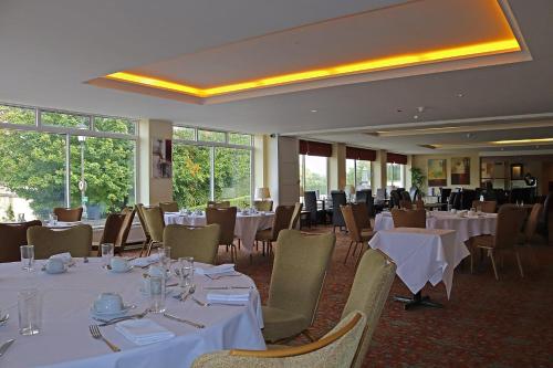 un comedor con mesas y sillas blancas en Shillingford Bridge Hotel, en Wallingford