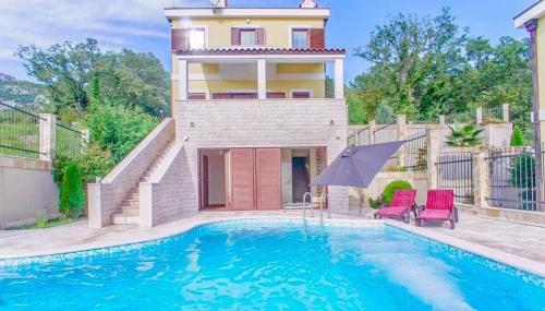 a house with a swimming pool in front of a house at Sunbreeze Delux Vilas in Budva