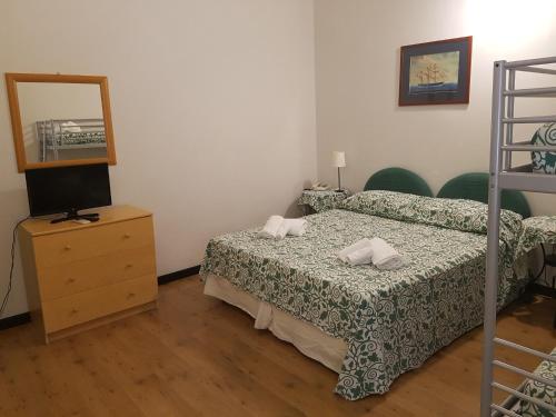 a bedroom with a bed and a dresser with a mirror at Albergo Lungomare in Bonassola