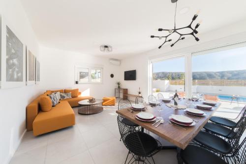 a dining room and living room with a table and chairs at Villa Belveder in Pag