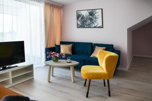 a living room with a blue couch and a table at STELLA Resort & SPA in Władysławowo