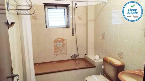 a bathroom with a tub and a toilet and a sink at Sol e Praia - Consolação I in Consolação