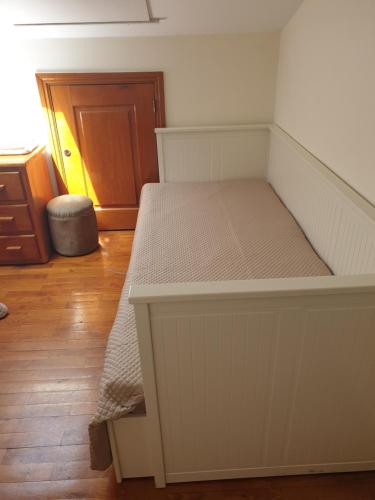 a white bed in a room with a wooden floor at hostel do Ermal in Vieira do Minho