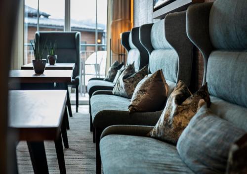 uma fila de sofás num quarto com almofadas em Hotel Königgut em Wals