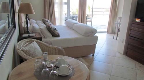 a living room with a bed and a table with a coffee table at Bentley on the Beach in Umhlanga