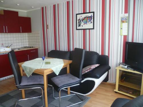 a living room with a table and chairs and a kitchen at Ferienhaus 1 in Elbingerode
