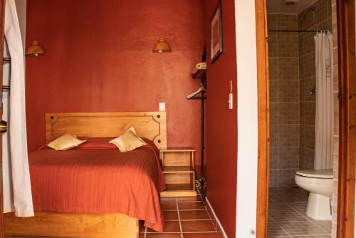 a bedroom with a bed and a bathroom with a toilet at Hotel Casa Margarita in San Cristóbal de Las Casas