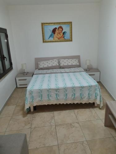 CampomarinoにあるNel Cuore di Campomarinoのベッドルーム1室(ベッド1台、テーブル2台付)、壁の絵画が備わります。
