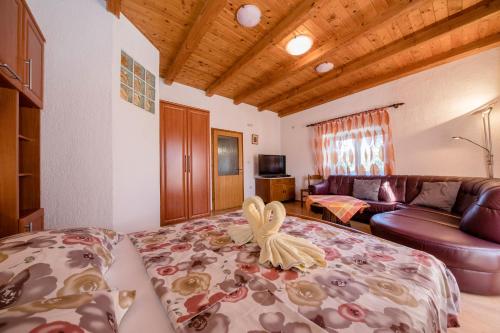 a living room with a bed with a bird on it at Landhaus am Berg in Rab