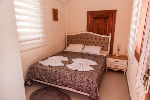 a bedroom with a bed with two towels on it at Lily Town Hotel in Antalya