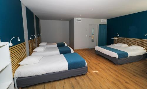 Habitación con 2 camas, paredes azules y suelo de madera. en Hotel Restaurant L'Espassole, en Thuir