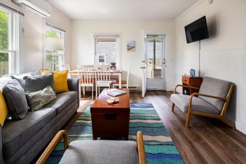a living room with a couch and a table at Truro Beach Cottages in Truro