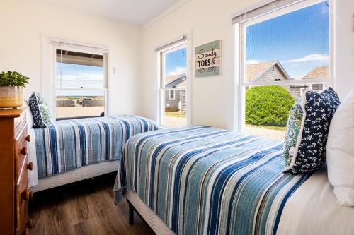 1 dormitorio con 2 camas y ventana en Truro Beach Cottages, en Truro