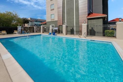 a large blue swimming pool in front of a building at La Quinta Inn & Suites by Wyndham Fort Worth Arlington West in Arlington
