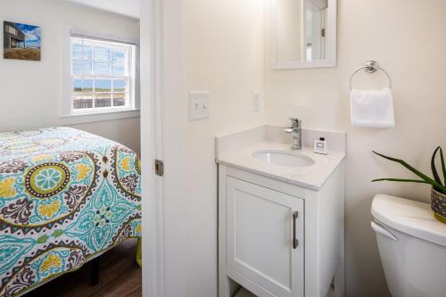 baño con lavabo y cama en Truro Beach Cottages, en Truro