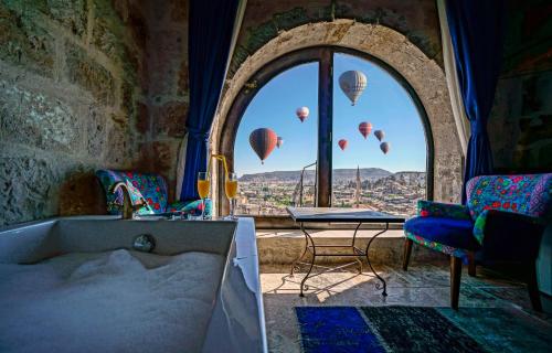 a bath tub in a room with hot air balloons in the sky at Arinna Cappadocia in Goreme