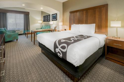 a hotel room with a large bed and a desk at La Quinta Inn & Suites by Wyndham Fort Worth Arlington West in Arlington