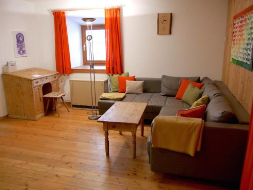 uma sala de estar com um sofá e uma mesa em Chasa Marugg - Ferienwohnung für 4-5 Personen, 70m2 em Scuol