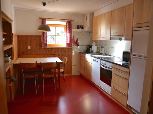 a kitchen with wooden cabinets and a table and chairs at Chasa Marugg - Ferienwohnung für 4-5 Personen, 70m2 in Scuol