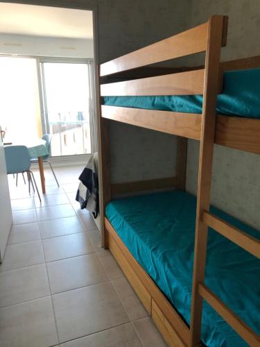 - une chambre avec des lits superposés dans une chambre avec une table dans l'établissement LES CEDRES, Résidence LES OCEANES, à Pornichet