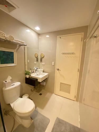 a bathroom with a toilet and a sink and a shower at Venice Luxury Studio w/Balcony @McKinley Hill in Manila